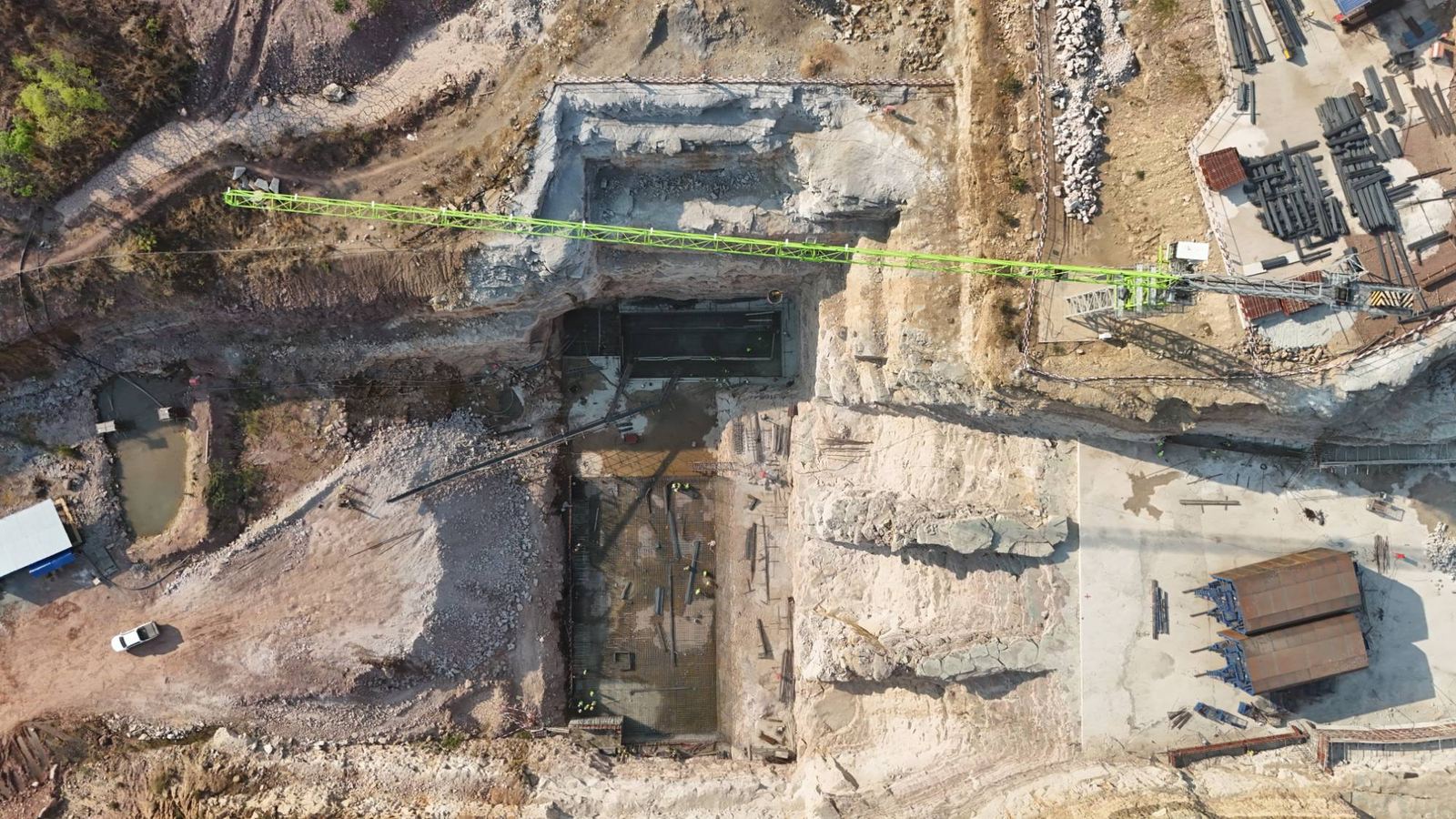 Drone view looking down into the powerhouse pit, with the tower crane jib across it