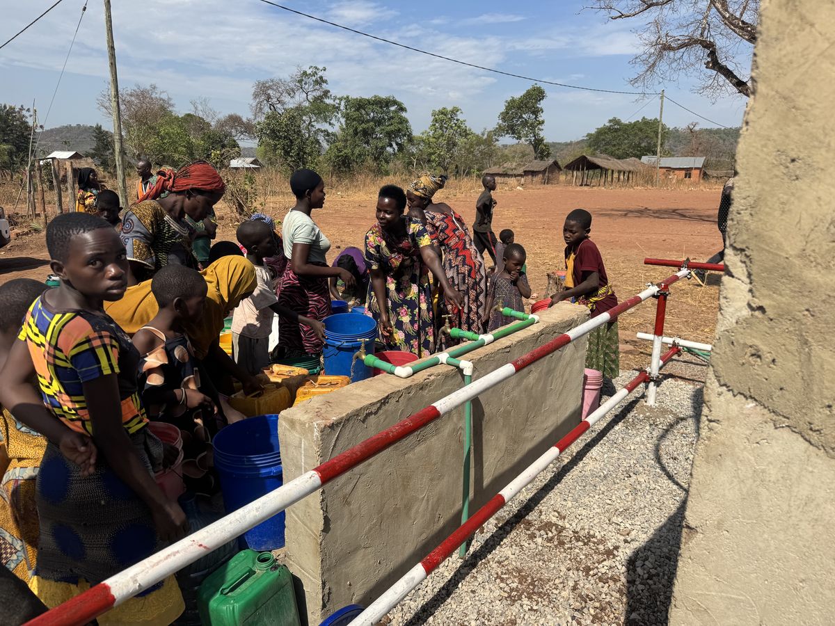 Villagers crowding the communal tap stands with buckets