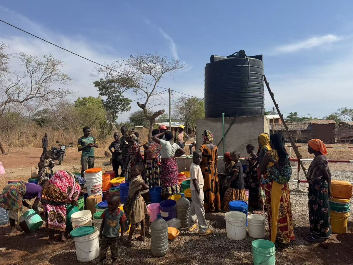 Storage tank on its plinth with villagers drawing water below