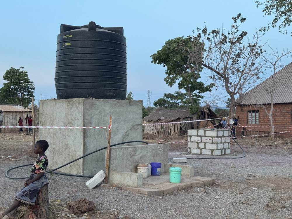 Storage tank on its plinth with masonry tap stands in use