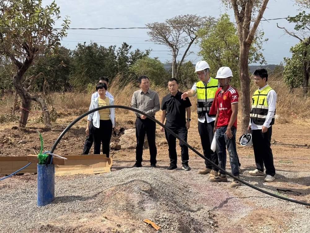 Company leaders inspecting the flowing borehole