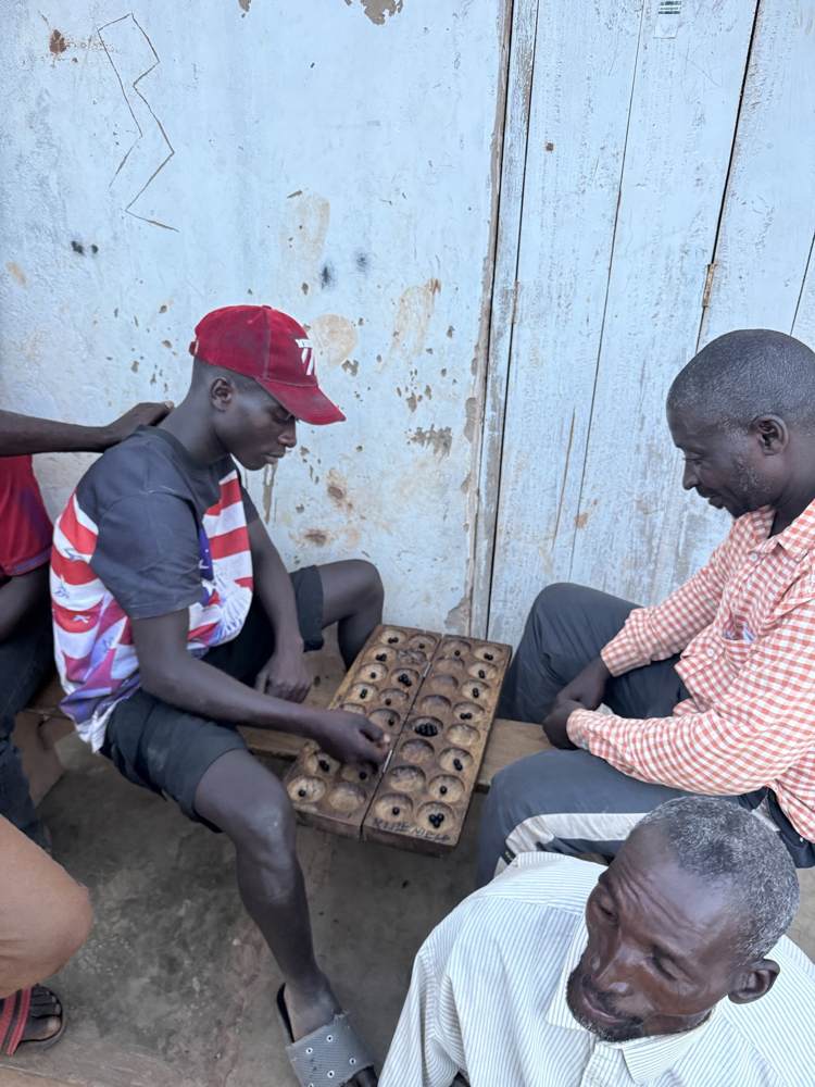 Men playing bao in the shade