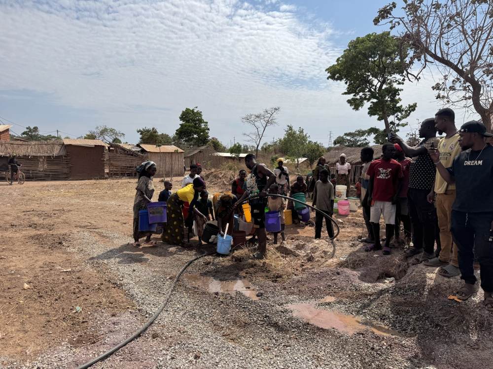 Villagers queuing with buckets at the new water point